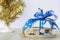 A Christmas gift with a large blue bow is lying on a wooden sleigh. Happy New year and merry Christmas