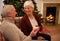 Christmas, gift and love with a senior couple in celebration while sitting in the living room of their home together