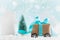 Christmas gift or present box on wheels against turquoise bokeh background. Holiday greeting card with snow effect.