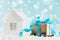 Christmas gift or present box on wheels against turquoise bokeh background. Holiday greeting card with snow effect.