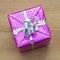 Christmas gift with ribbon wrapped in a shiny purple paper