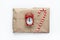 Christmas gift wrapped in brown craft paper, tied with scourge, decorated with cane candy and small analog clock on white