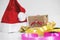 Christmas gifts preparation on white table with. Red santa hat with gift box and colorful ribbon
