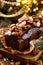 Christmas gingerbread cake covered with chocolate and decorated with nuts and almonds on the holiday table.