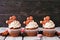 Christmas gingerbread cupcakes in a row against rustic wood