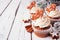 Christmas gingerbread cupcakes on a rustic white wood background with copy space