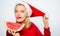 Christmas girl eat watermelon. Exotic winter holiday. Celebrate new year summer. Girl wear santa hat eat slice