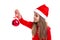 Christmas girl holding and looking at a christmas tree toy in the hand, wearing a santa hat isolated over a white