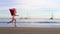 Christmas Girl Santa Claus running at ocean sandy beach with large red bag full of presents - New Year vacation and