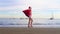 Christmas Girl Santa Claus walking at ocean sandy beach with large red bag full of presents - New Year vacation and