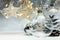 christmas glass balls hanging against grey background with blurred garland lights