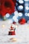 Christmas glass snowball with little toy Santa indoor with red home festive decor and blurred bokeh background in daylight