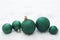 Christmas glitered green baubles, balls isolated on snow. Winter greeting card with copy space