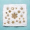 Christmas golden snowflakes pattern in snow on light blue background, top view. Flat lay.