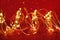 Christmas. Golden xmas lights wire on red background