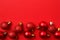 Christmas greating card composition. Christmas red balls decorations on red background. Flat lay, top view, copy space