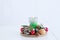 Christmas green candle in decorative decoration on table. White background