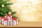 Christmas greeting card with gifts boxes on wooden table and tree bokeh background. Xmas and happy new year