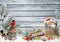 Christmas greeting card with space for text, with gifts, a lantern, a bullfinch, a bag of letters and sweets on a snowy wooden boa