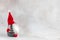 Christmas handmade gnome in red hat side view holiday banner on light winter background