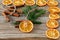 Christmas handmade natural decorations. Garland and fir tree toy made of dried slices of oranges on wooden table. Winter still