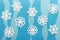 Christmas handmade paper composition with white paper snowflakes and blue paper layers