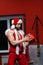 Christmas. Handsome muscular man in Santa Claus costume with a gift . GYM