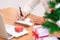 Christmas and Happy New Year blessing concept. Man wearing white sweater writing and sending greeting card