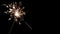 Christmas or Happy New Year concept. Close up banner of Bright burning sparkler on a black background with copy space.