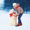 Christmas happy teenager boy playing with white Samoyed dog in winter, dog gives paw child on snow