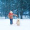 Christmas happy teenager boy running playing with white Samoyed dog on snow in winter day