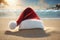 Christmas hat on the beach with a blue sky and sea in the background, xmas wallpaper