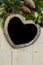 Christmas heart chalkboard on a wooden background with festive foliage