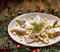 Christmas Herrings fillets with apples, pickled cucumbers, red onion and spices on a ceramic plate