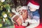 Christmas holiday. Baby in Santa hat opening box of gifts