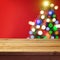 Christmas holiday background with empty wooden deck table over Christmas tree bokeh. Ready for product montage