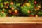 Christmas holiday background with empty wooden deck table over festive bokeh. Ready for product montage