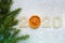 Christmas holiday background. Figures 2020 on a white wooden background, dried orange slices, spruce branches.