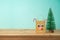 Christmas holiday background with paper bag as cute reindeer character and pine tree on wooden table
