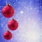 Christmas holiday balls hanging over blue bokeh background with copy space