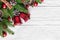 Christmas holiday composition with fir tree, christmas bells, berries and pine cones on white wooden background