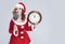 Christmas Holiday Concept and Ideas. Portrait of Gleeful Red-Haired Santa Helper With Iced Lolly and Big Round Clock. Posing