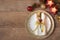 Christmas holiday dinner place setting - plates, napkin, cutlery, gold bauble decorations over oak table background. Fork and