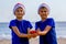 Christmas holiday. Kids in red Santa hats holding christmas decoration at sunny beach