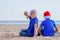 Christmas holiday. Kids in red Santa hats at sunny beach