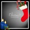 Christmas holiday season background with Christmas candle with fire, red socks with candy canes and holly berries.