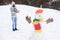 Christmas holidays. Active lifestyle. Snow games. Leisure on fresh air. Snowman and cheerful bearded hipster knitted hat