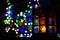 Christmas holidays festive lights inside home in dark room with foreground lantern with candle and background blurred bokeh