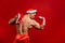 Christmas holidays. strong santa claus wearing hat. Young muscular man. red background.