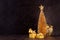 Christmas home decor in dark, golden color - Christmas tree, star, balls in bowl, gift box, ribbons in dark interior on brown wood